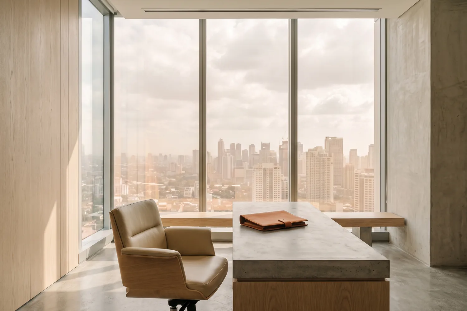 A calm, light-filled executive interior with a single chair and a long timber table